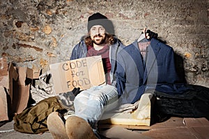 Jobless man with cardboard Code for food sign