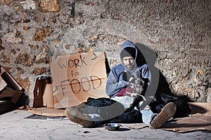 Jobless man with dog, sitting next to alms bowl