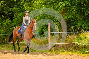 Jockey girl doing horse riding on countryside meadow