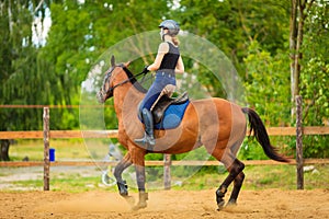 Jockey girl doing horse riding on countryside meadow