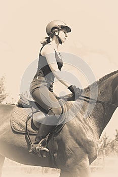 Jockey girl doing horse riding on countryside meadow