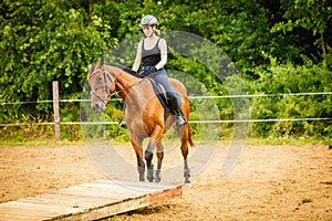 Jockey girl doing horse riding on countryside meadow