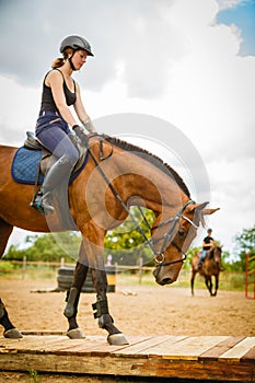 Jockey girl doing horse riding on countryside meadow