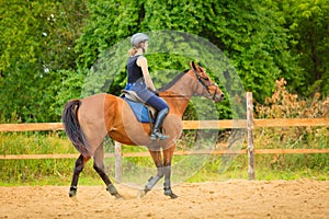 Jockey girl doing horse riding on countryside meadow