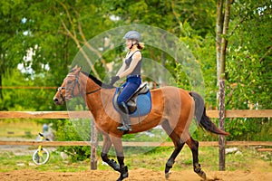 Jockey girl doing horse riding on countryside meadow