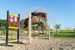 Jockey jumps over a hurdle