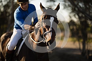 Jockey riding horse at barn