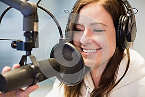 Jockey Smiling While Using Headphones And Microphone In Radio St