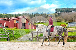 Jockey training with her horse in an equestrian center
