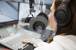 Jockey Wearing Headphones While Using Microphone In Radio Studio