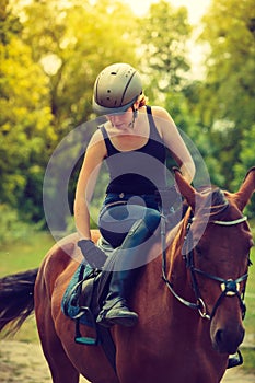 Jockey young woman getting horse ready for ride