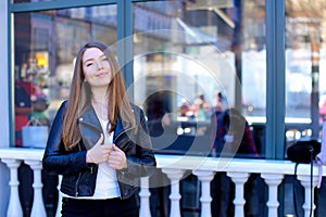 Jocund girl standing with glasses outside.