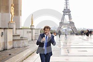 Jocund guy raving near Eiffel Tower and calling friend b