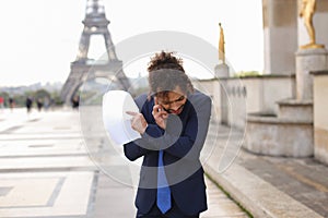 Jocund guy raving near Eiffel Tower and calling friend b