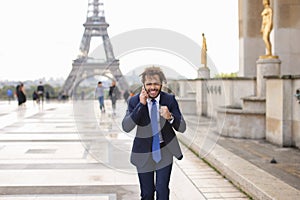 Jocund mulatto guy raving near Eiffel Tower and calling friend b