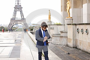 Jocund mulatto guy raving near Eiffel Tower and calling friend b