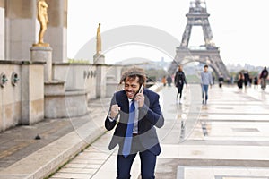 Jocund mulatto guy raving near Eiffel Tower and calling friend b