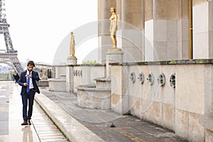 Jocund mulatto guy raving near Eiffel Tower and calling friend b