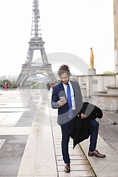 Jocund mulatto guy raving near Eiffel Tower and calling friend b