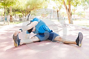 Jogger Doing Workout Before Running On Track In Park