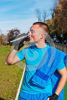 Jogger drinking water after workout