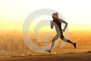 Jogger running in city outskirts at sunset
