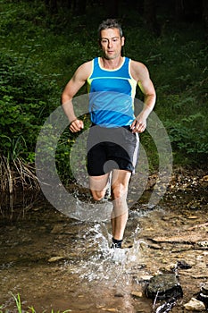 Jogger running through a streambed