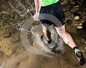 A jogger is running through a streambed