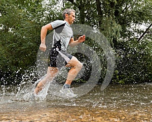 Jogger running through a streambed