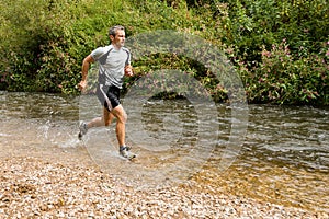 Jogger running through a streambed