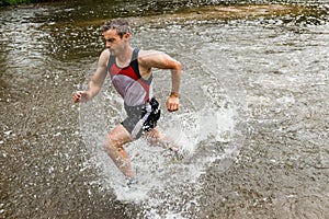 Jogger running through a streambed