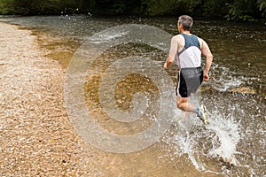 Jogger running through a streambed