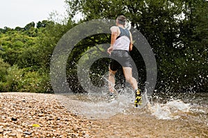 Jogger running through a streambed