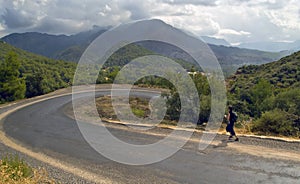 Jogger on serpentine road in mountains