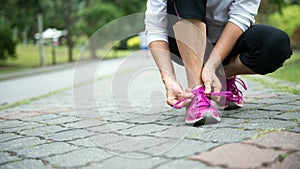 Jogger tighten her running shoe laces