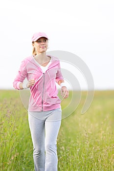 Jogging sportive young woman running park field