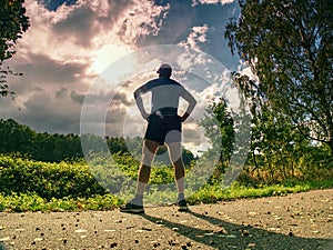 Jogging tall sports man in trees shadows with sun light behind
