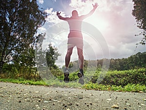 Jogging tall sports man in trees shadows with sun light behind