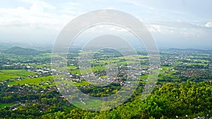 Jogjakarta city from the top of the hills. Landscape with home residents and fresh green trees view in between.