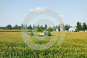 A john deere crop sprayer spreading insecticide at a farm in ontario