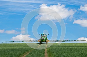 John Deere R4040i sprayer spraying in wheat field