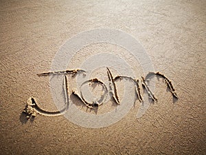 A John name written on the beach.