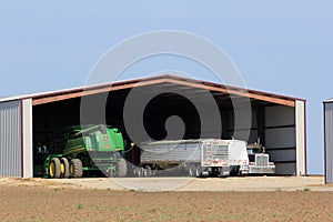 Johndeere Combine and wheat trucks in a garage on a farm north of Lyons Kansas.