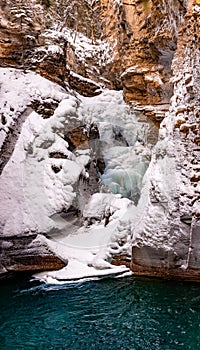Johnston Canyon Waterfall - Frozen Lower Falls with turquoise pool below Banff National Park AlbertaCanada