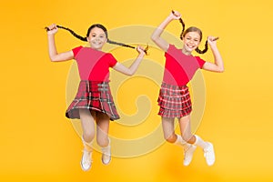 Join celebration. Cheerful friends schoolgirls jumping yellow background. Celebrate holiday. Scottish holiday. Kids girl