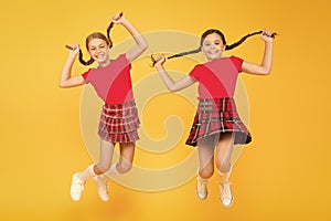 Join celebration. Cheerful friends schoolgirls jumping yellow background. Celebrate holiday. Scottish holiday. Kids girl