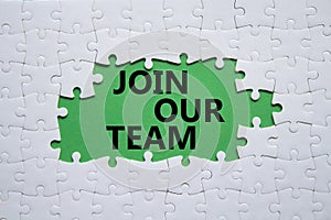 Join our team symbol. Concept words Join our team on white puzzle. Beautiful green background. Business and Join our team concept