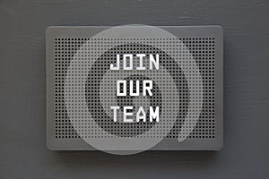 `Join our team` words on a black lightbox on a black background, top view. Flat lay, overhead, from above