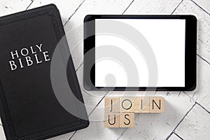 Join Us in Block Letters on a White Wooden Table with a Black Bible and Tablet