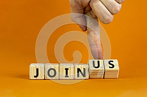 Join us symbol. Businessman turns wooden cubes and changes concept words Join to Join us. Beautiful orange background. Business